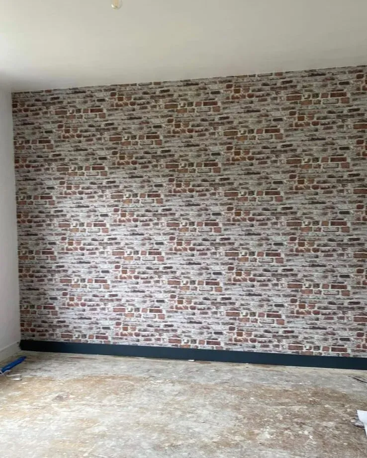 Papier peint effet briques sur un mur de séjour à Vire