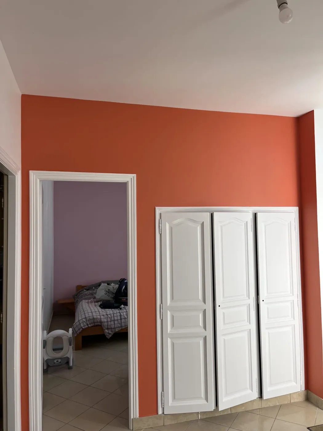 Mur peint en orange terracotta dans une chambre, Calvados