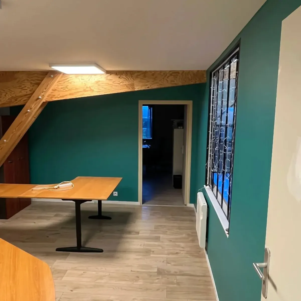 Mur peint en vert profond dans un bureau sous combles à Vire
